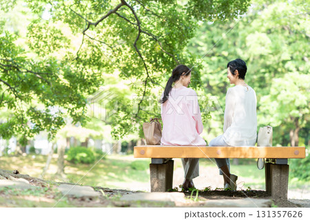 一位老年婦女坐在公園長椅上的背影 131357626