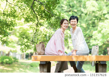 老年婦女在綠樹成蔭的公園聊天 131357628