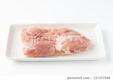 Raw chicken thighs on a plate on a white background Raw chicken thighs on a plate on a white background 131357886