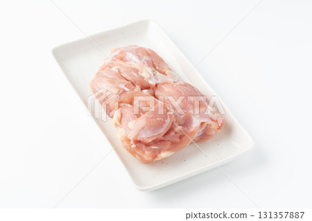 Raw chicken thighs on a plate on a white background 131357887