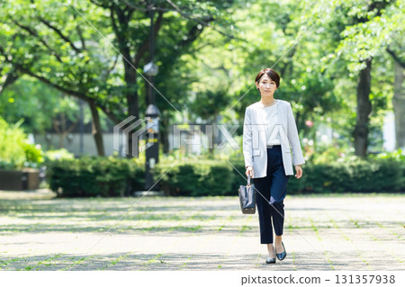 Business woman walking in fresh green 131357938
