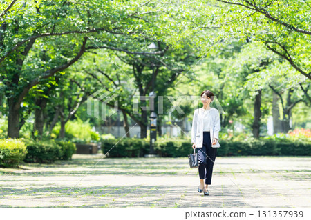 Business woman walking in fresh green Business woman walking in fresh green 131357939