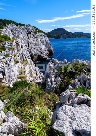 和歌山白崎海岸，石灰岩巨石遍布的海岸線，遠處有陡峭的白色岩壁和山脈 131358162