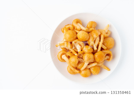 Large nameko mushrooms on a plate on a white background 131358461