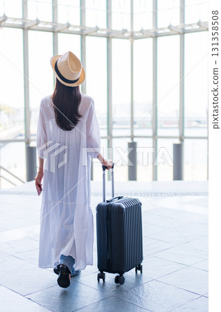 A woman traveling with a suitcase 131358508