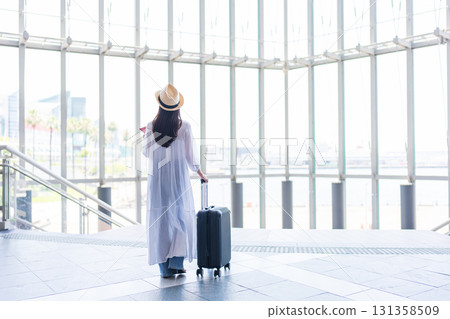 A woman traveling with a suitcase 131358509