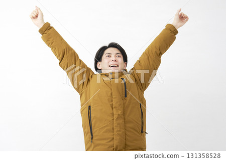 Man wearing down jacket stretching white background 131358528