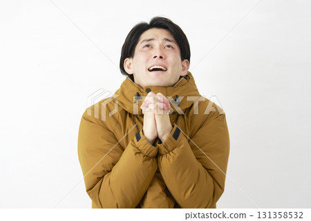 Man wearing down jacket pleading white background Man wearing down jacket pleading white background 131358532