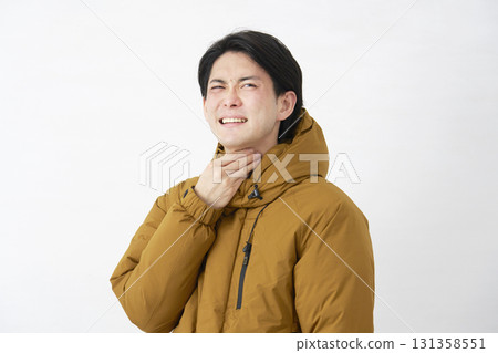 Man wearing down jacket, sore throat, white background 131358551