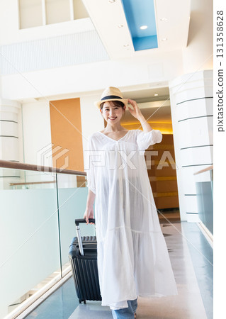 A woman walking down an airport corridor 131358628
