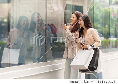 Black Friday Shopping. Two women admiring window displays while holding shopping bags. 131359051