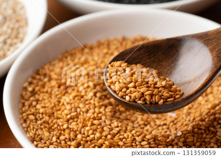 Close-up of golden sesame seeds (raw sesame seeds) on a spoon Close-up of golden sesame seeds (raw sesame seeds) on a spoon 131359059