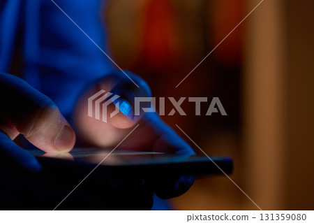 Hand using smartphone in dark room 131359080