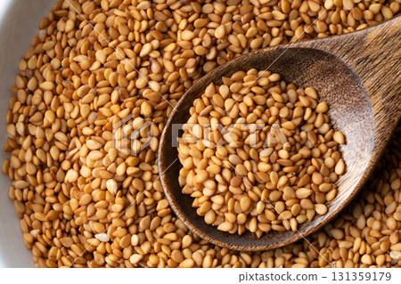 Close-up of golden sesame seeds (raw sesame seeds) on a spoon Close-up of golden sesame seeds (raw sesame seeds) on a spoon 131359179