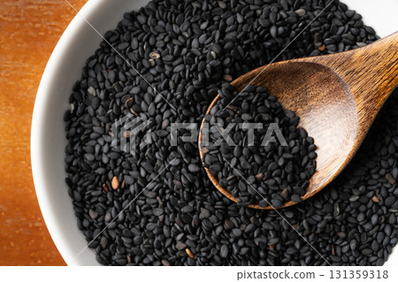 Close-up of black sesame seeds (raw sesame seeds) on a spoon 131359318