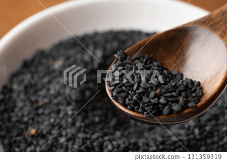 Close-up of black sesame seeds (raw sesame seeds) on a spoon 131359319