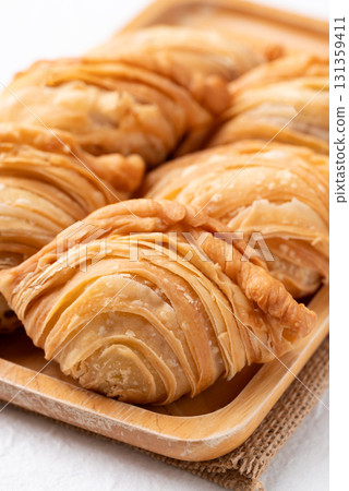 Curry puff stuffed with chicken or sweet potatoes on wooden plate, Thai snack food style 131359411