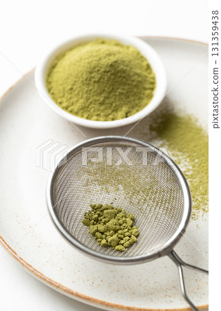 Matcha green tea powder in sieve on plate prepare for tea mixing Matcha green tea powder in sieve on plate prepare for tea mixing 131359438