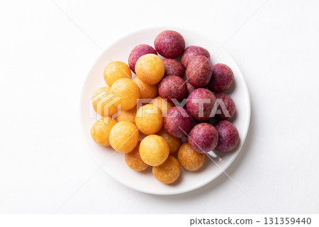 Top view of deep fried sweet potato balls on plate with white background, Thai street food snack Top view of deep fried sweet potato balls on plate with white background, Thai street food snack 131359440