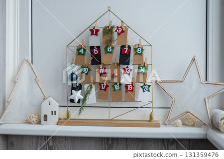 Number on craft paper notes with tasks before Christmas holidays. Female making kraft paper for handmade advent calendar Made with your own hands step by step DIY 131359476