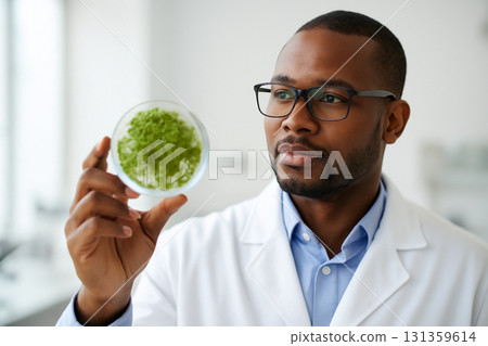 AI generated image of an African American male scientist examining algae in a petri dish for biofuel research in a bright clean lab. A hopeful expression of innovation and scientific progress. 131359614