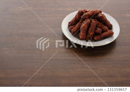 Brown sugar karinto (black karinto) on a plate on the table background Brown sugar karinto (black karinto) on a plate on the table background 131359657