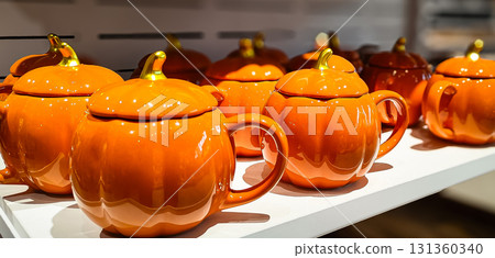 Orange pumpkin cups with lids on a store shelf. Orange pumpkin cups with lids on a store shelf. 131360340