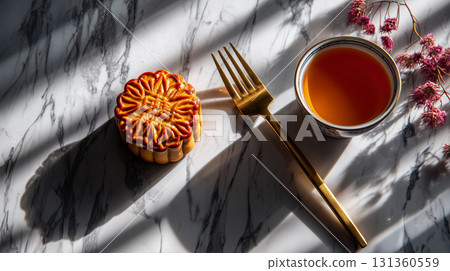 Mooncake with tea and fork on marble surface 131360559