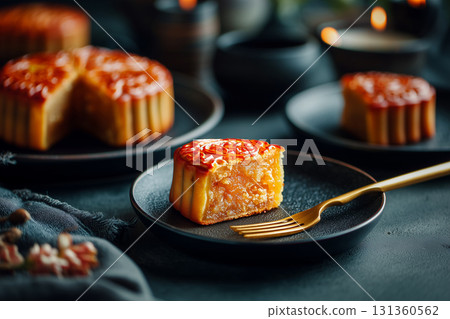slice of mooncake on black plate with golden fork 131360562