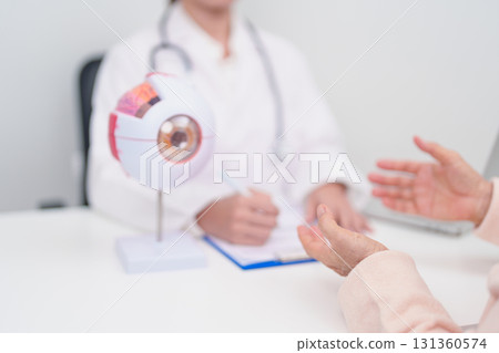 Elderly Patient consulting Doctor to Eye disease, Senior Medical Diagnosis. Anatomy Eye model for Cataract, Glaucoma, Age Related Macular Degeneration, Diabetic Retinopathy, Vitreous, health concept 131360574