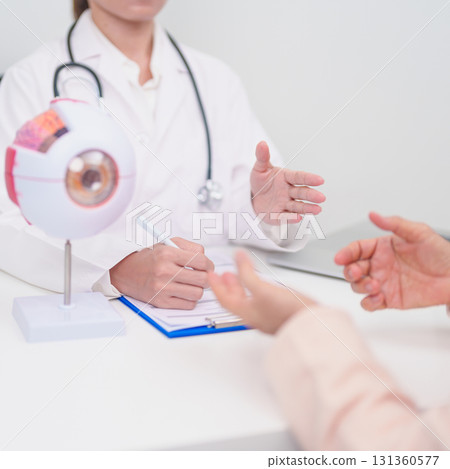 Elderly Patient consulting Doctor to Eye disease, Senior Medical Diagnosis. Anatomy Eye model for Cataract, Glaucoma, Age Related Macular Degeneration, Diabetic Retinopathy, Vitreous, health concept 131360577