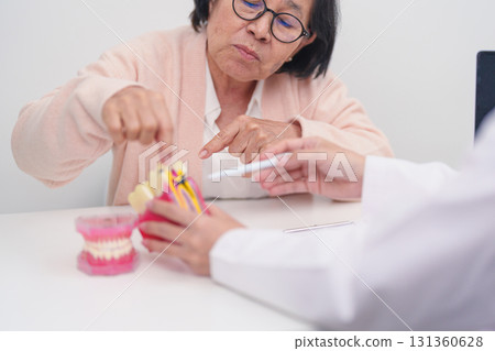 Elderly Patient consulting Dentist to Tooth disease, Senior Health Medical Diagnosis. Anatomy teeth model for Oral Teeth decay, Scrape off tartar. March Oral health, Dentist Day, False Teeth concept 131360628