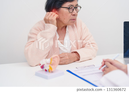 Elderly Patient consulting Doctor to Ear disease. Senior Health Medical Diagnosis. Anatomy Ear model for Atresia, Otitis Media, Pertorated Eardrum, Meniere syndrome, otolaryngologist, Hearing Loss Elderly Patient consulting Doctor to Ear disease. Senior Health Medical Diagnosis. Anatomy Ear model for Atresia, Otitis Media, Pertorated Eardrum, Meniere syndrome, otolaryngologist, Hearing Loss 131360672
