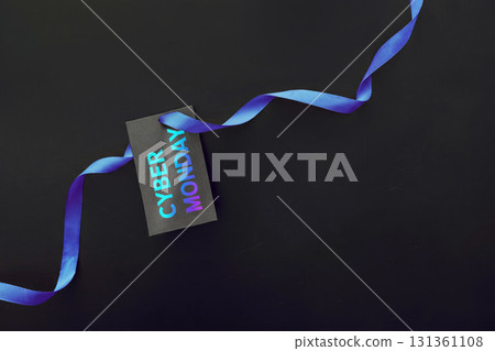Cyber Monday sale tag with blue ribbon on black background, minimalistic holiday shopping concept for online retail, ecommerce and digital discounts with copy space 131361108