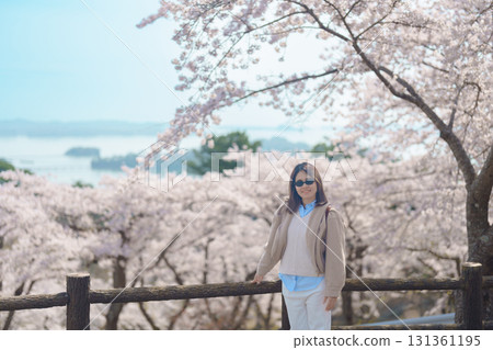 Woman tourist sightseeing Sakura Cherry Blossom in Spring. Happy traveler travel at Saigyo Modoshi no Matsu over Matsushima Bay in Matsushima, Miyagi Prefecture, Japan. Famous Landmark and Vacation Woman tourist sightseeing Sakura Cherry Blossom in Spring. Happy traveler travel at Saigyo Modoshi no Matsu over Matsushima Bay in Matsushima, Miyagi Prefecture, Japan. Famous Landmark and Vacation 131361195