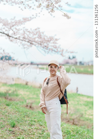 Woman tourist sightseeing Sakura Cherry Blossom in Spring. Happy traveler travel near Hinokinai River riverbank in Kakunodate town, Semboku District, Akita Prefecture, Japan. Landmark and Vacation 131361256