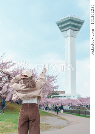Woman tourist sightseeing Goryokaku Tower park with Sakura Cherry Blossom in Spring, happy traveler travel in Hakodate city, Hokkaido, Japan. famous Landmark, Japan Travel and Vacation destination 131361283