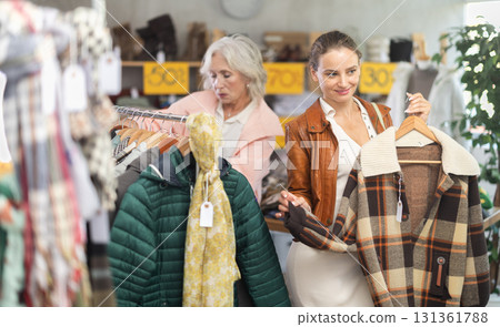 Woman customer examine and choose plaid jacket in store 131361788