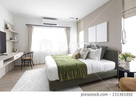 Modern bedroom interior with gray and green bedding. Picture frame on wall. 131361892