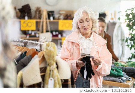 Elderly woman choosing gloves in clothing store 131361895