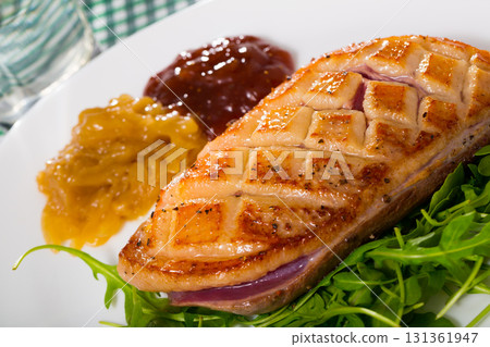 Fried duck breast Magre served with tasty sauces and arugula 131361947