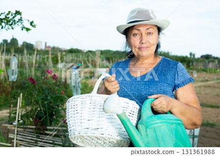 Smiling aged woman standing in home vegetable garden on summer day 131361988