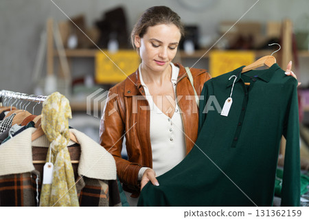 Woman choosing a warm dress in a store 131362159