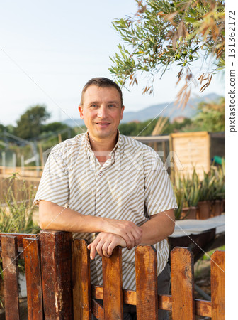 Portrait of positive man at fence 131362172