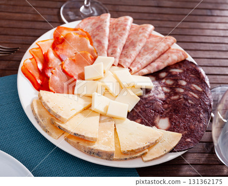 Slicing of smoked sausage, ham, dried pork carbonade and cheese 131362175