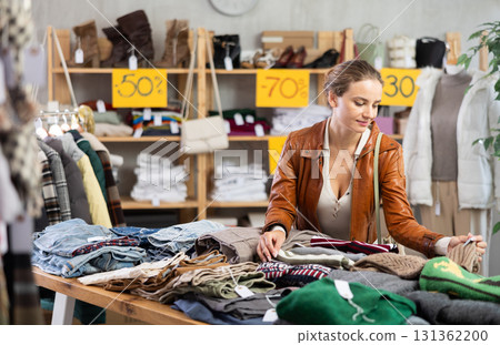 Woman choosing knitwear in store Woman choosing knitwear in store 131362200