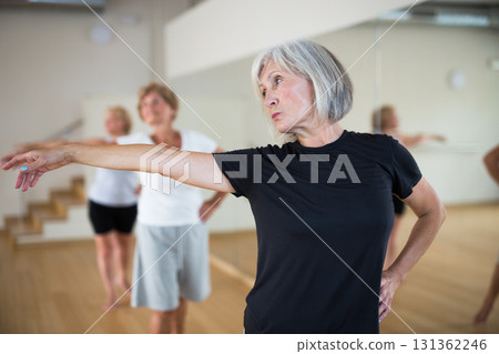 Mature woman learning classical ballet technique in choreography class Mature woman learning classical ballet technique in choreography class 131362246