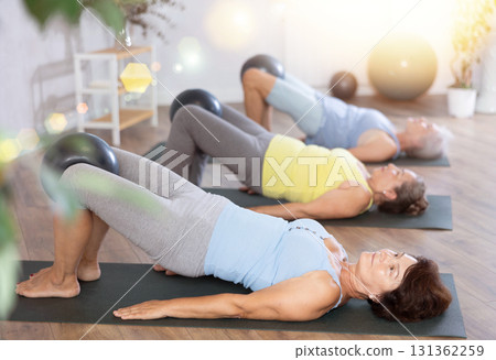 Group of elderly woman doing pilates with soft ball in studio Group of elderly woman doing pilates with soft ball in studio 131362259