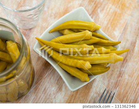 Pickled okra pods on plate, homemade preserves Pickled okra pods on plate, homemade preserves 131362346