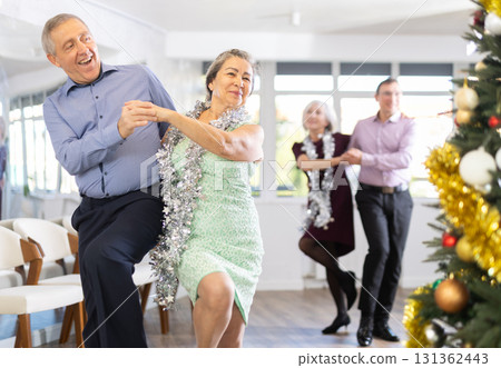 Active mature man and woman enjoying celebration Christmas at ballroom and dancing rock and roll dance Active mature man and woman enjoying celebration Christmas at ballroom and dancing rock and roll dance 131362443